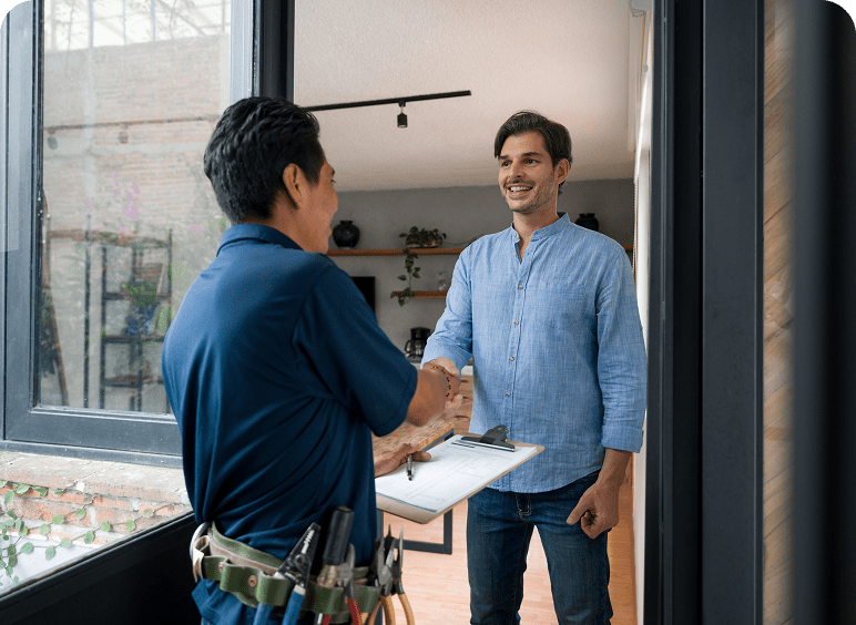 Two men shaking hands at doorway.
