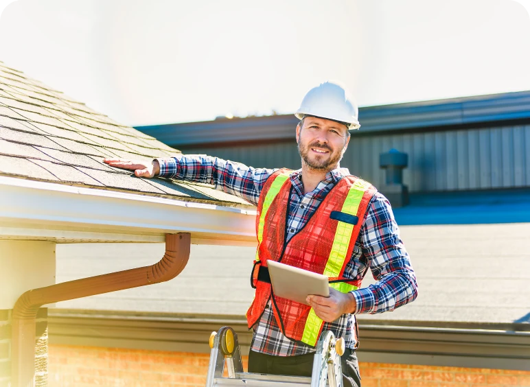 Man inspecting roof with a tablet.