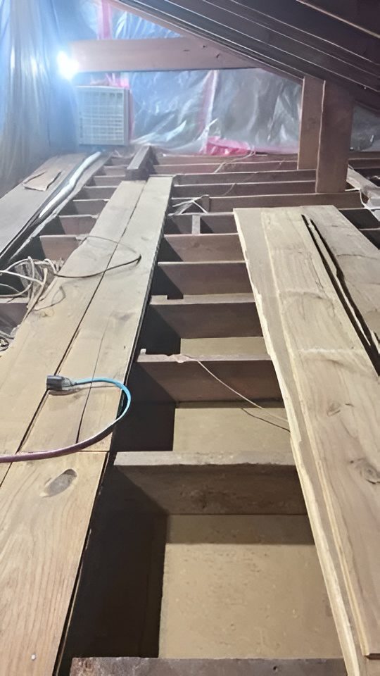Attic renovation showing exposed floor joists and planks